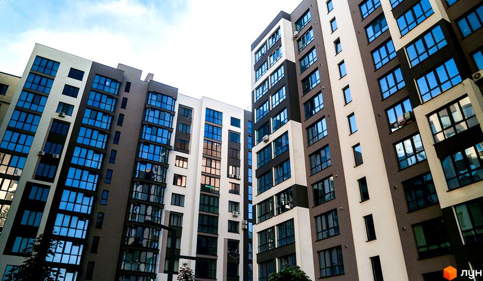 Зображення фасаду Житлового комплексу Паркова Алея з великими вікнами. Багатоповерхівки з прибудинковою територією.