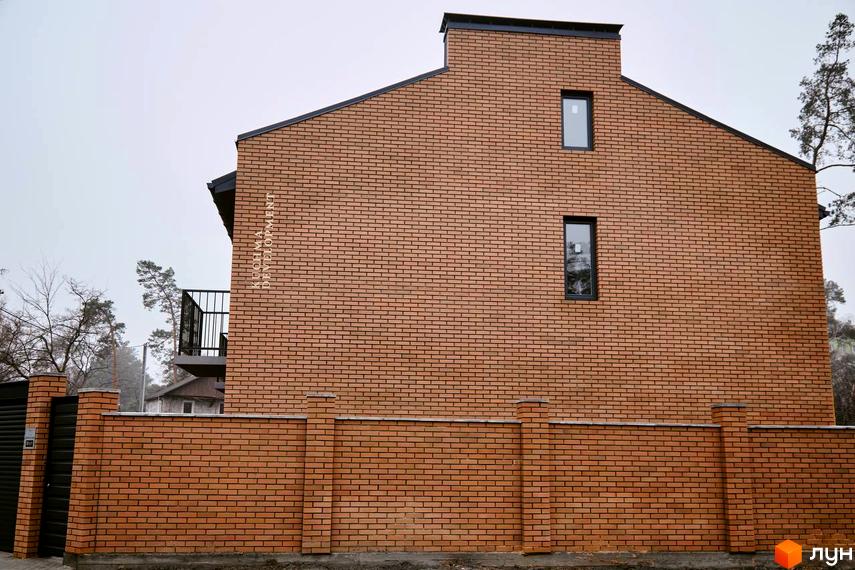 Таунхауси „Позітано Центр 2“: цегляний будинок з двома вікнами та балконом, огороджений цегляним парканом.
