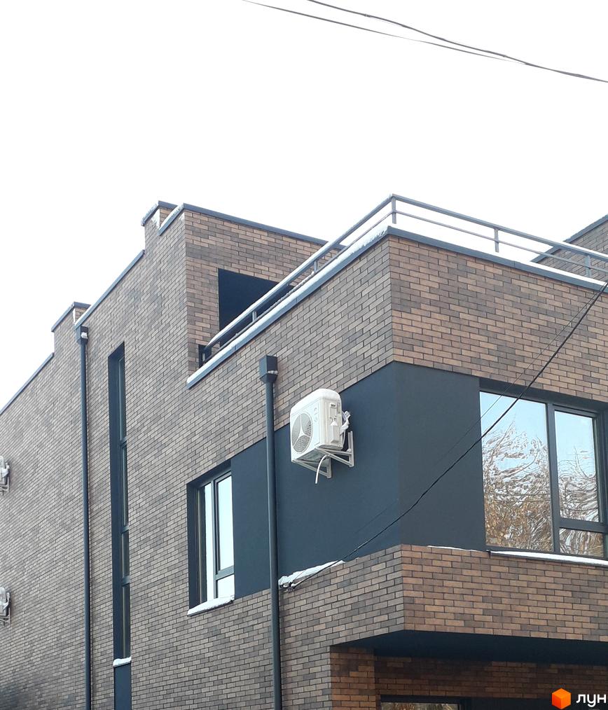 Зовнішній вигляд житлового комплексу на вул. Новий Світ-бічна, 13. Будинок з цегляним фасадом та кондиціонером.