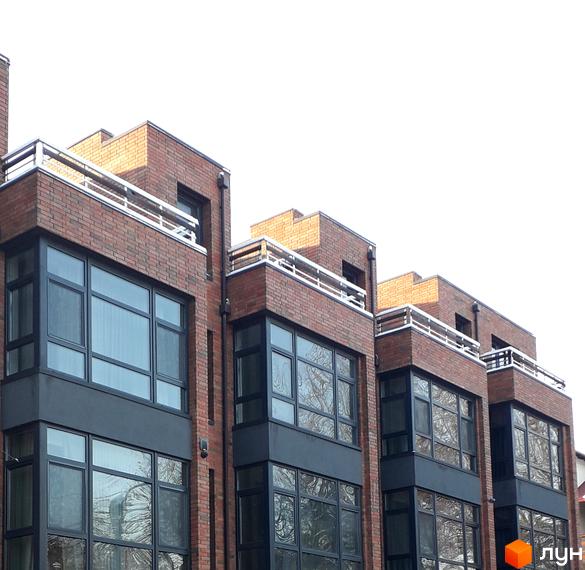 Цегляний будинок з панорамними вікнами та балконами. Новобудова розташована за адресою вул. Кармелюка, 1.