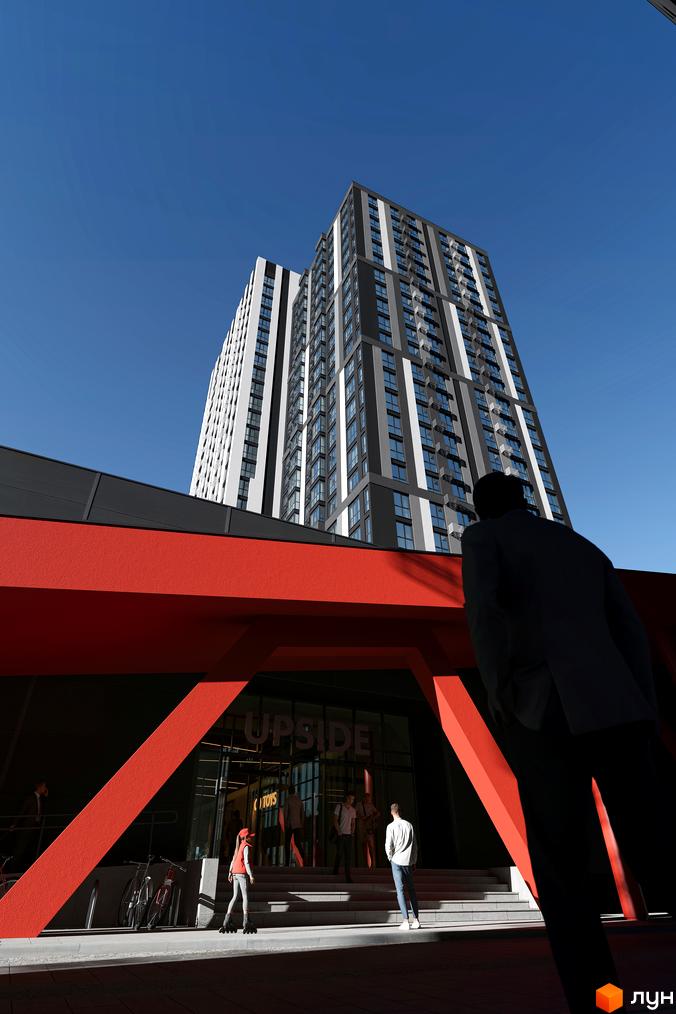 Житловий комплекс Avalon Up – це сучасна новобудова з двома висотними будинками, що домінує на фоні блакитного неба. Перед будівлею розташований вхід з червоною аркою та сходами, де видно людей.