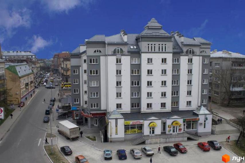 Зображення фасаду та прибудинкової території Житлового комплексу на вулиці Пилипа Орлика, 7-7a. Багатоповерхова будівля з парковкою та тротуарами.