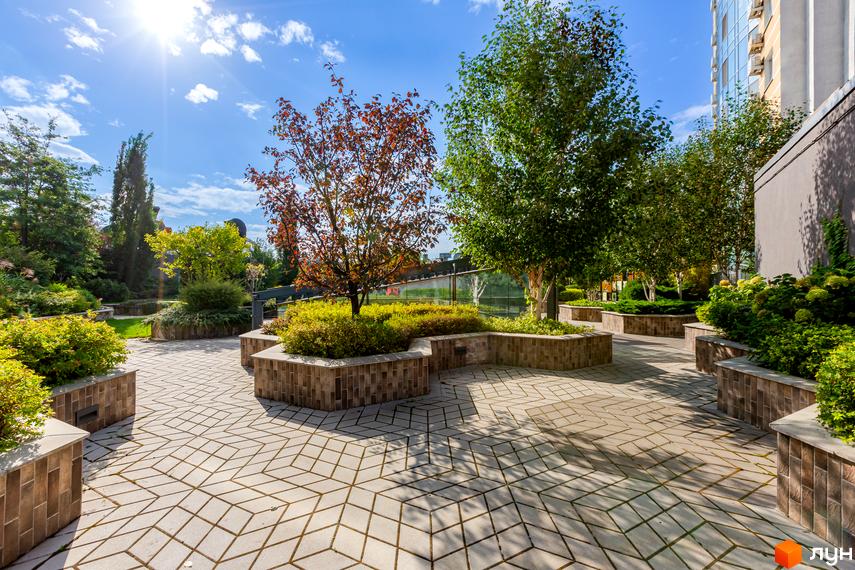 Зовнішній вигляд житлового комплексу ЖК Smart Plaza Polytech з прибудинковою територією, озелененням та доріжками.