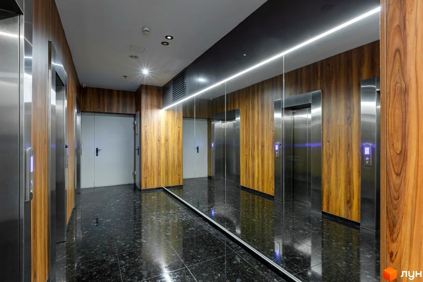 Сучасний ліфт у будівельному проєкті Smart Plaza Polytech. Інтер'єр з дерев'яними панелями та дзеркальними поверхнями.