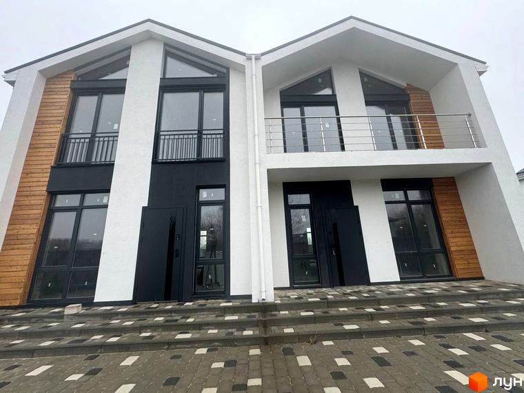 Дуплекси Family House: два будинки з білим фасадом, великими вікнами, чорними та дерев'яними елементами. Перед ними вимощена бруківкою територія зі сходами.