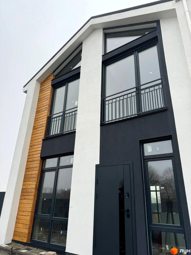 Сучасний дуплекс Family House з дерев'яними та білими фасадами, великими вікнами та балконом.