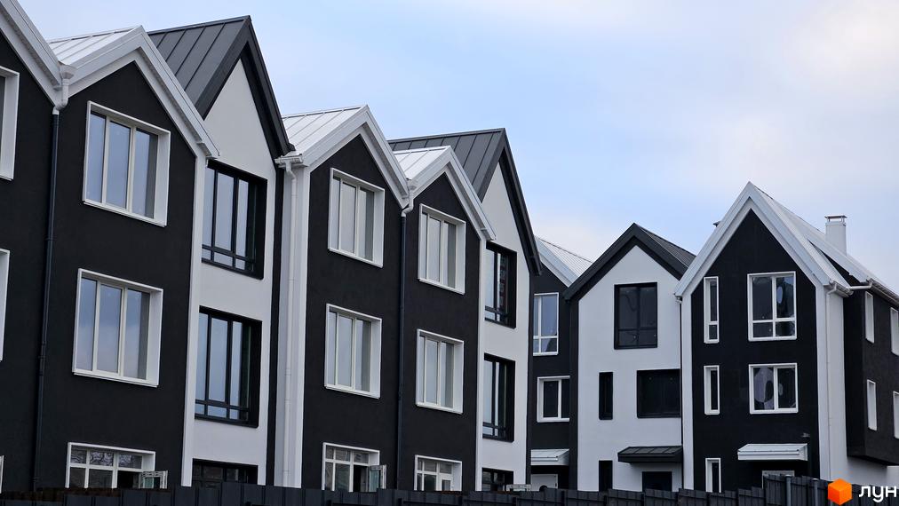 Таунхаус New Smart 15 - сучасна архітектура з чорно-білими фасадами та великими вікнами. Комплекс розташований на фоні блакитного неба.