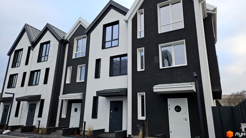 Зовнішній вигляд таунхаусів New Smart 15 з чорно-білими фасадами та великими вікнами. Новобудова з акуратними вхідними групами.