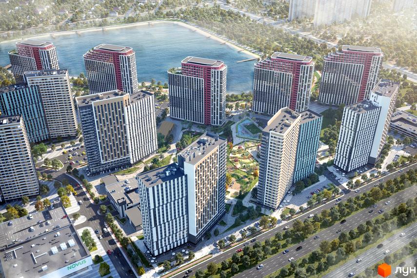 Вигляд з висоти на Житловий комплекс H2O з багатоповерховими будинками біля озера. Навколо будинків зелені насадження та дороги.