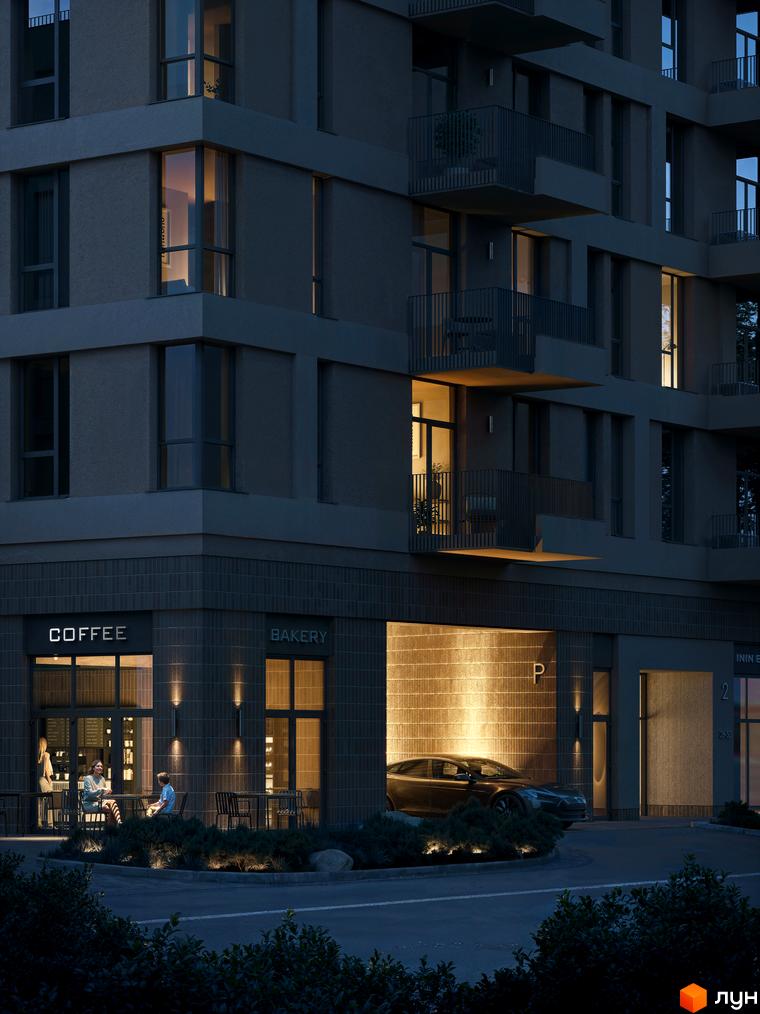 Житловий комплекс Avalon Magnolia ввечері з освітленими вікнами та балконами. На першому поверсі розташовані кав'ярня та пекарня з відвідувачами, а також в'їзд до паркінгу.