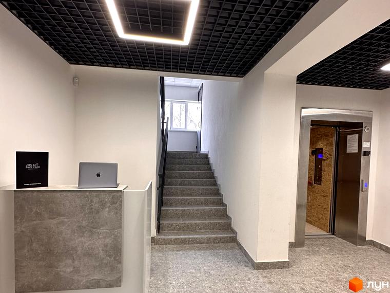 Вхідна група житлового комплексу Всі Свої з рецепцією та ліфтом. Сучасний дизайн інтер'єру з акцентом на функціональність та комфорт.