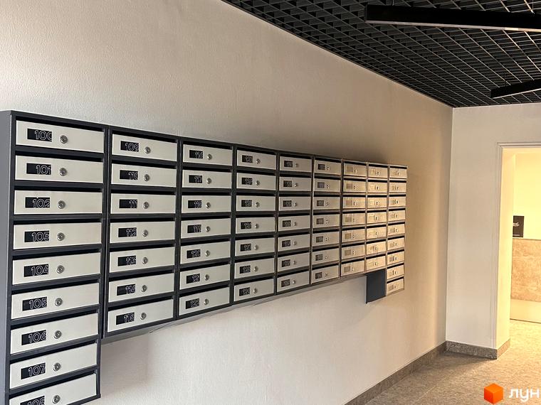 Відділення поштових скриньок у новобудові ЖК Всі Свої. Кожна скринька має номер від 100 до 129, що забезпечує зручність для мешканців.