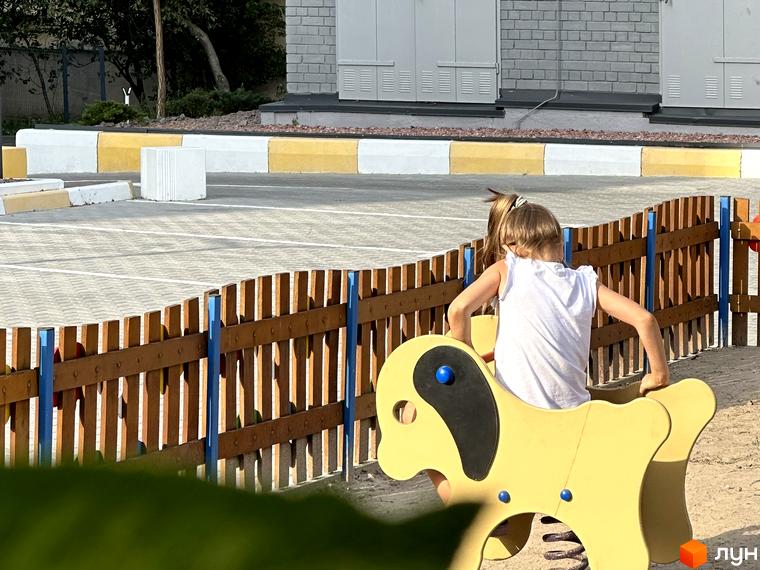 Діти граються на дитячому майданчику біля житлового комплексу Всі Свої. Територія комплексу облаштована для відпочинку та дозвілля.