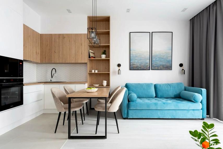Дизайн кухні-вітальні в ЖК Всі Свої з блакитним диваном та обідньою зоною. Сучасний інтер'єр квартири з дерев'яними елементами та картинами на стіні.