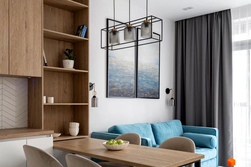 Вітальня з блакитним диваном та дерев'яними меблями. Сучасний дизайн інтер'єру квартири в новобудові ЖК Всі Свої.