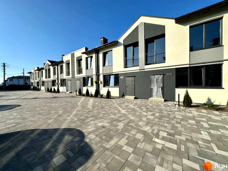 Фасад таунхаусів COMFORT RESIDENCE з великими вікнами та дверима. Бруківка на прибудинковій території.