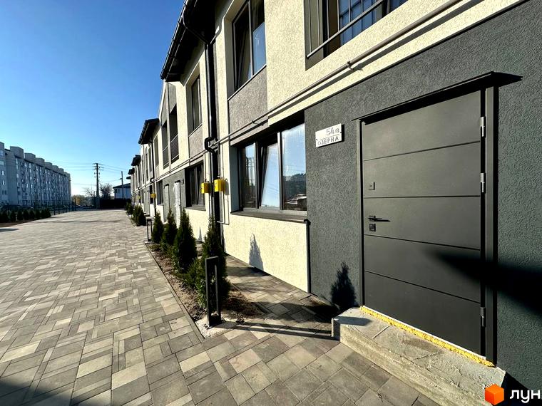 Таунхауси COMFORT RESIDENCE з сірим фасадом та бруківкою перед будинком. Зовнішній вигляд будівель та прибудинкової території.