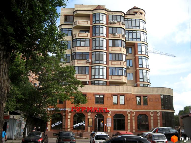 Житловий комплекс Армійський має багатоповерхову будівлю з цегляним фасадом та численними вікнами. Перед будинком розташовані дерева та припарковані автомобілі.