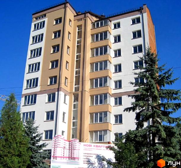 Зображення фасаду багатоповерхового будинку на вулиці Целевича, 4а. На передньому плані зелені дерева та рекламна вивіска Житлового комплексу.