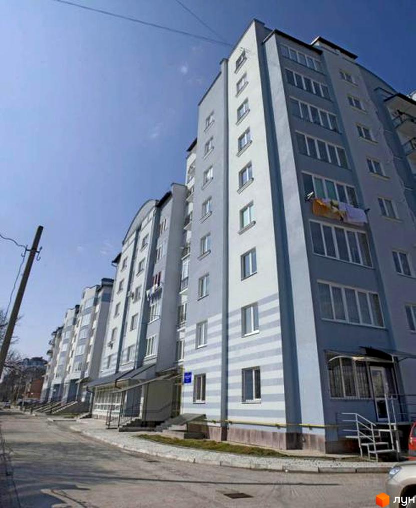 Зовнішній вигляд багатоповерхового будинку на вулиці Чорноти. Житловий комплекс з великими вікнами та балконами.