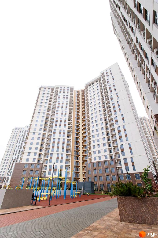 Новобудова KADORR City з багатоповерховими будинками та спортивним майданчиком на прибудинковій території.