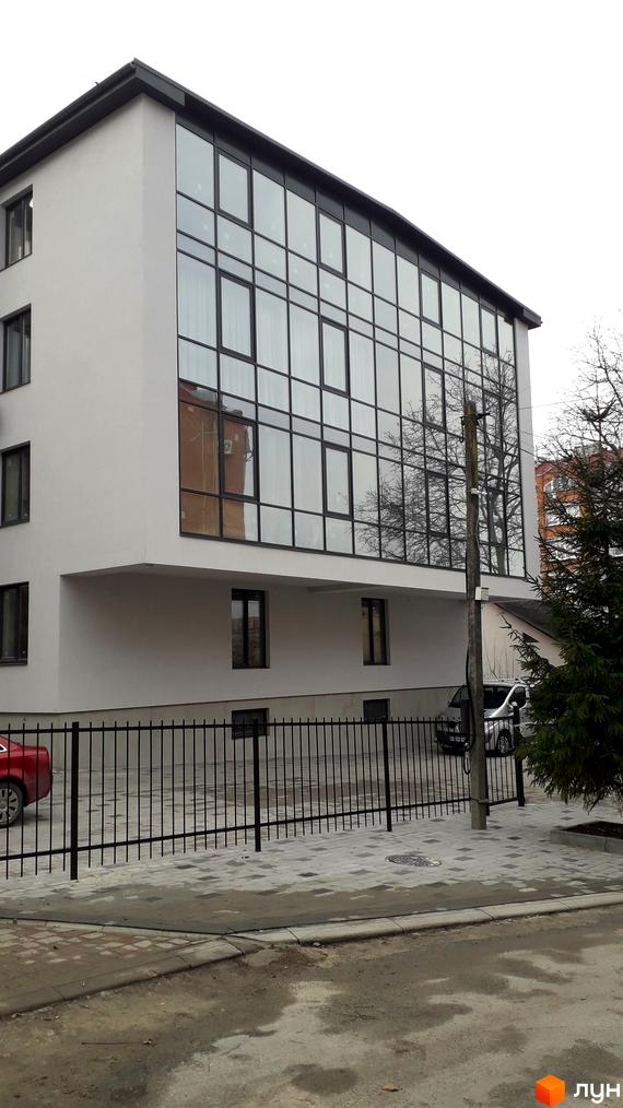 Будівельний проєкт на вул. Квітки Цісик, 54, з великими панорамними вікнами та чорною огорожею навколо прибудинкової території.