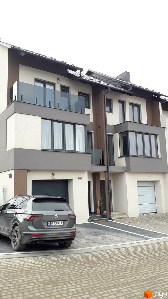 Зовнішній вигляд новобудови на вул. Квітки Цісик, 31, з прибудинковою територією та автомобілем. Комплекс має сучасний дизайн з великими вікнами та балконами.