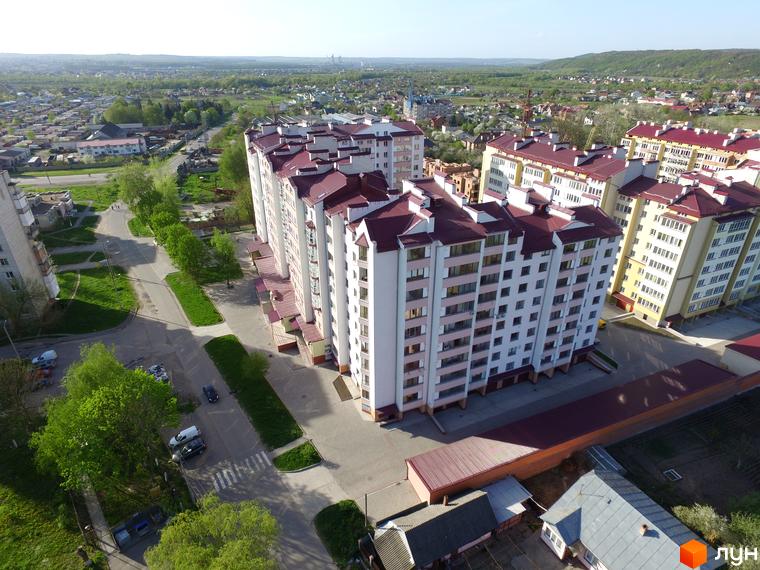 Фото багатоповерхового будинку Житловий комплекс Затишна оселя з червоним дахом. Вигляд з висоти на житловий масив.