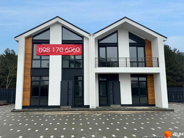 Сучасні дуплекси WoodSky з панорамними вікнами та дерев'яними елементами фасаду, перед якими розташований впорядкований двір з бруківкою.