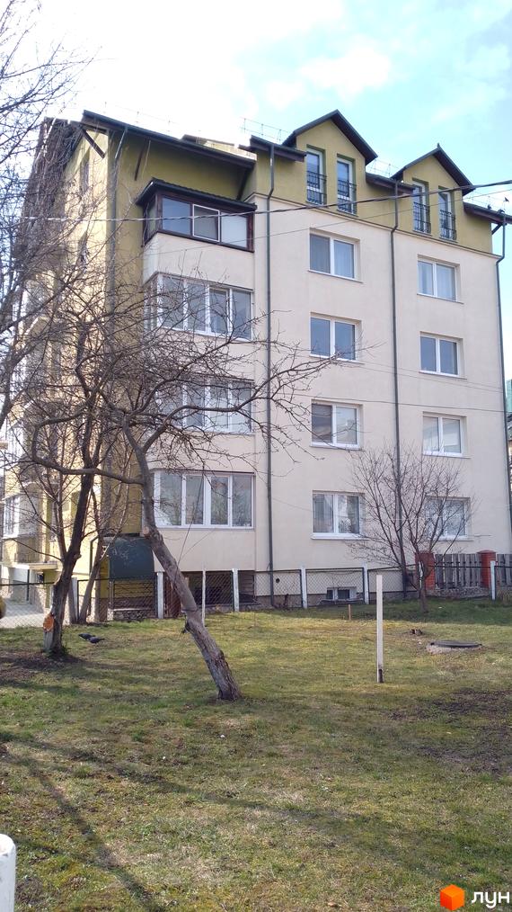 Зовнішній вигляд багатоповерхового будинку на вулиці Новий Світ, 17а, з прибудинковою територією та деревами. Новобудова з фасадом світлого кольору та вікнами.