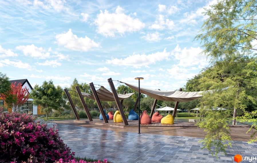 Котеджне містечко Ovillas: затишна зона відпочинку з яскравими кріслами-мішками під навісом та зеленою зоною перед будинком.