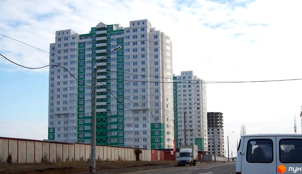 Житловий комплекс Європейський з багатоповерховими будинками та прибудинковою територією. Вид на фасад будівель з зеленими елементами.