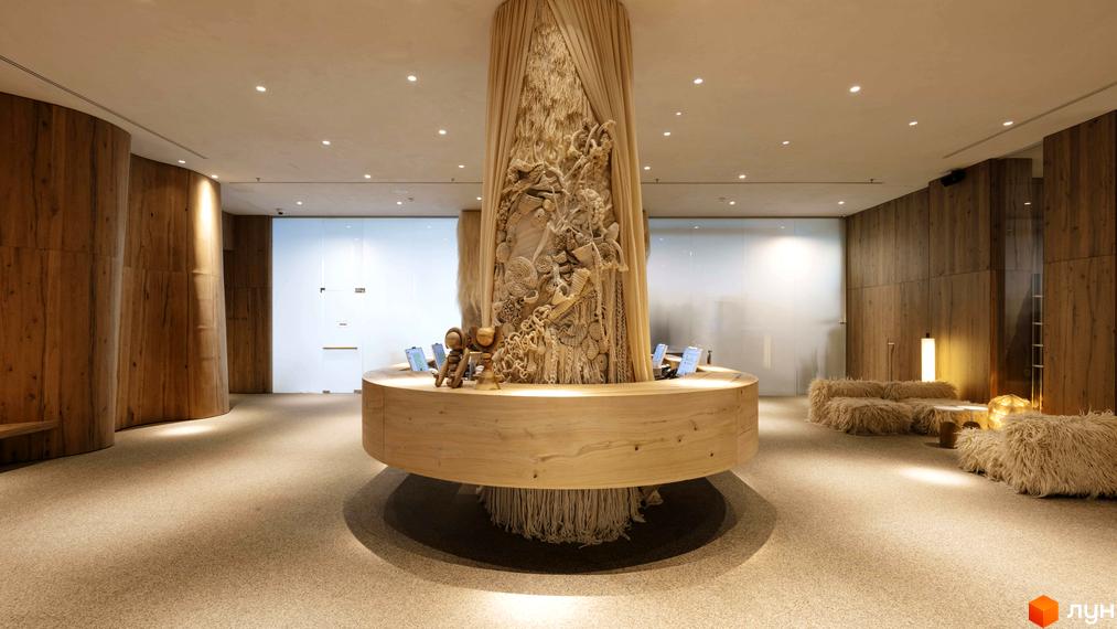 Інтер'єр апарт-комплексу Mountain Residence з дерев'яними елементами та арт-об'єктом у центрі. Затишна зона відпочинку з хутряними диванами.