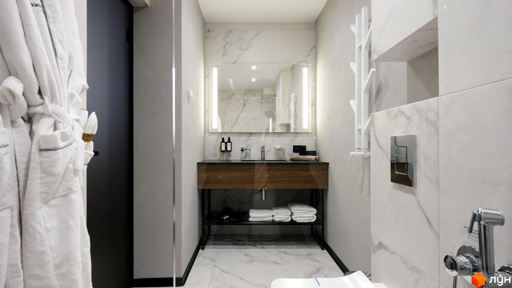Ванна кімната в апарт-комплексі Mountain Residence з білими халатами, мармуровою плиткою та дерев'яною тумбою під умивальник.