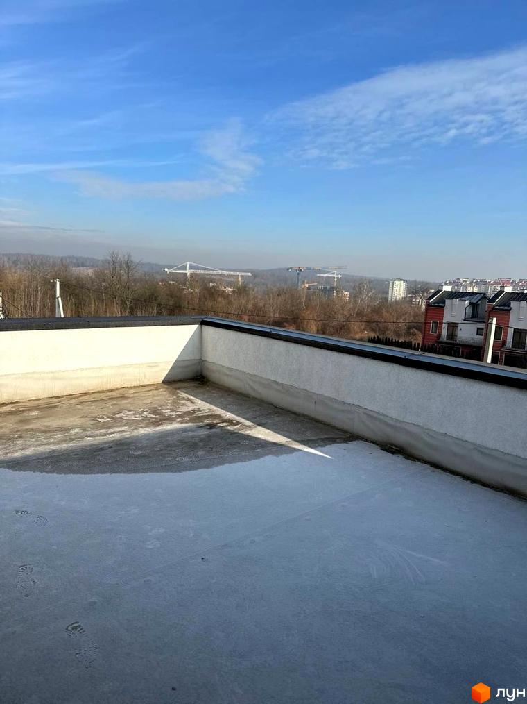 Вид з даху на житловий комплекс на вул. Пилипа Орлика, 51. Навколо будівельні крани та міський пейзаж.