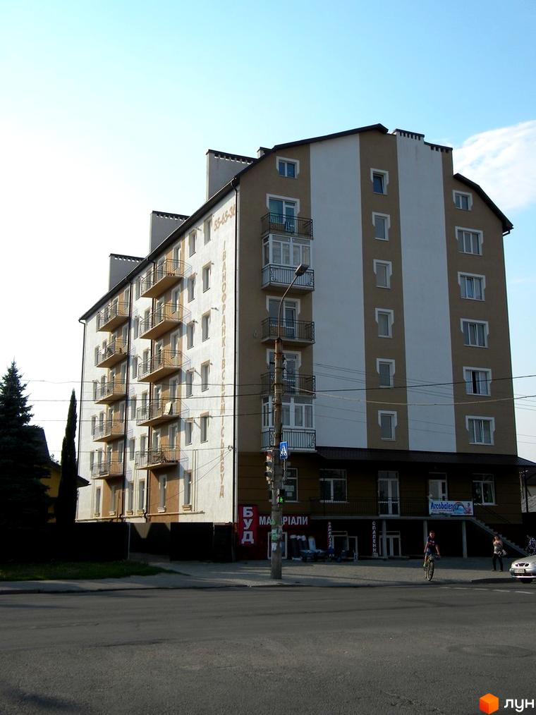 Зображення фасаду будинку на вулиці Коновальця, 260. Багатоповерхова будівля з балконами та великими вікнами.