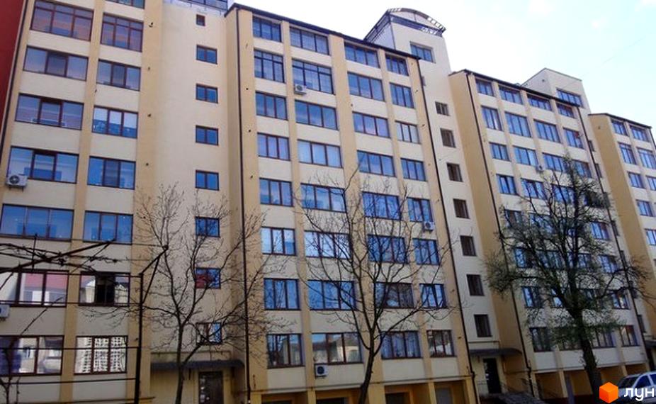 Зовнішній вигляд житлового будинку на вулиці Чорновола, 56. Багатоповерхова будівля з великими вікнами та світлим фасадом.