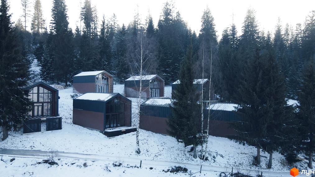Котеджне містечко КМ GORDO RESIDENCE з сучасними будинками та великими вікнами, розташоване серед засніженого лісу.