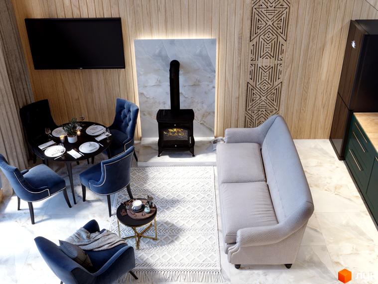 Інтер'єр вітальні з каміном та обідньою зоною в КМ GORDO RESIDENCE. М'які сині крісла та диван створюють затишну атмосферу.