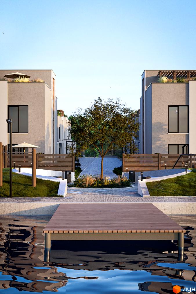 Котеджне містечко The Lake. Вид на будинки зі світлими фасадами, доріжку з деревом та дерев'яний пірс над водою.