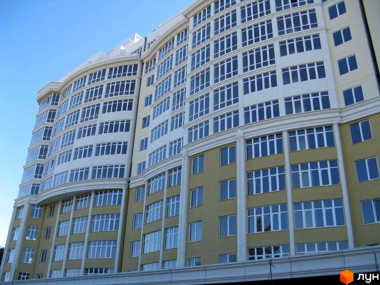 Житловий комплекс Аркадія Хіллс з фасадом, виконаним у світлих тонах, та великими вікнами. Прибудинкова територія облаштована для комфортного відпочинку.