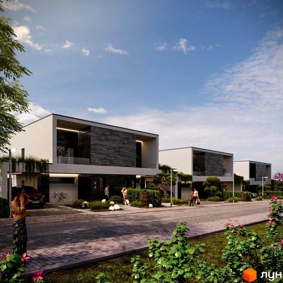 Триповерхові будинки з білими фасадами та темними вставками. На прибудинковій території зелені насадження, бруківка та дорога.