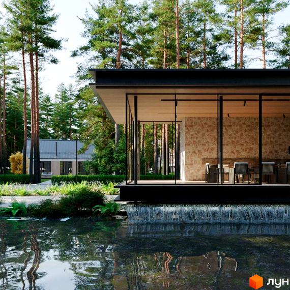 Будинок Котеджного містечка Green Village з панорамними вікнами та кам'яною стіною біля водойми з водоспадом. Навколо зелені насадження та сосновий ліс.