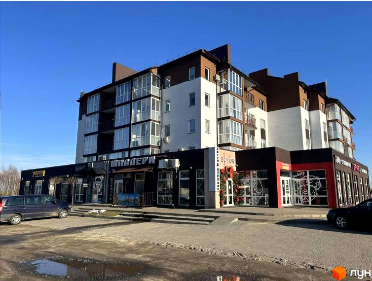 Зовнішній вигляд житлового комплексу Рать з комерційними приміщеннями на першому поверсі та прибудинковою територією.