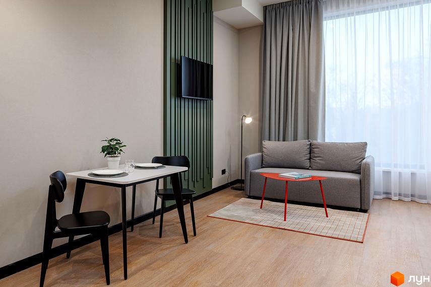 Інтер'єр апартаментів в Kristal Plaza. Простора кімната з обіднім столом, диваном та телевізором на стіні. Світлий дизайн з великим вікном та шторами.