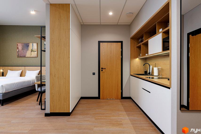 Інтер'єр апартаментів Апарт-комплекс Kristal Plaza: спальня з ліжком, кухня з вбудованою технікою та дерев'яною підлогою.