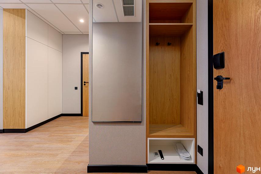 Інтер'єр коридору в апарт-комплексі Kristal Plaza: дерев'яні двері, шафа для одягу, дзеркало, світлі стіни та підлога.
