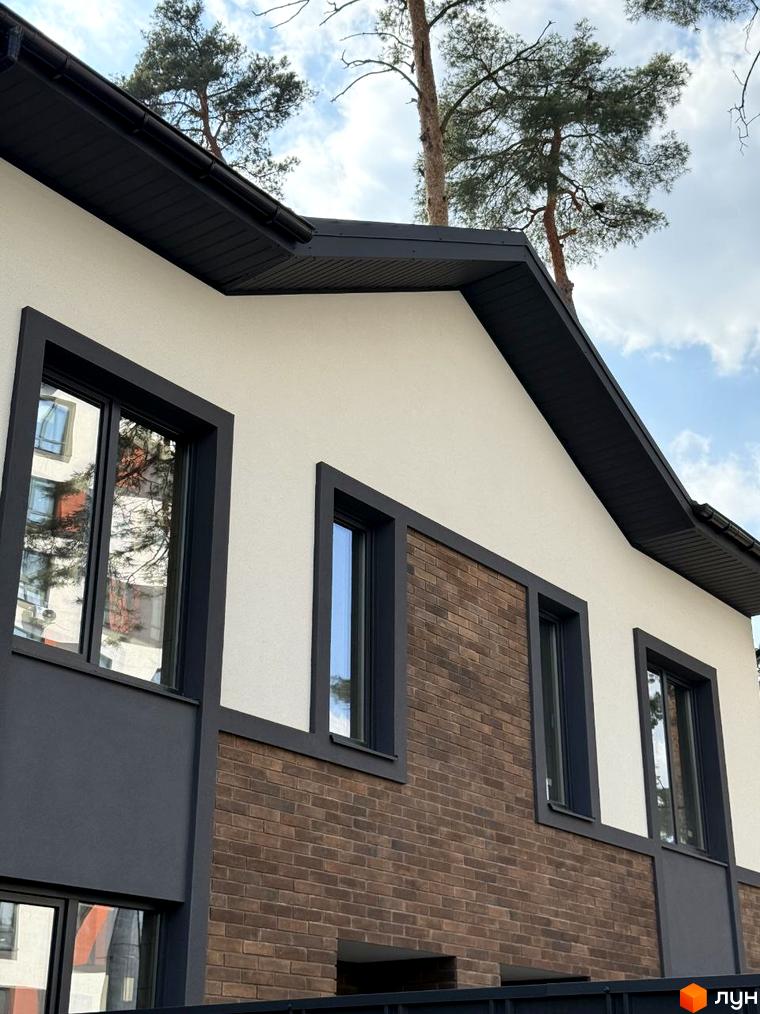 Зображення фасаду будинку на вулиці Павленка, 35. На фото видно частину будинку з вікнами та оздобленням з цегли.