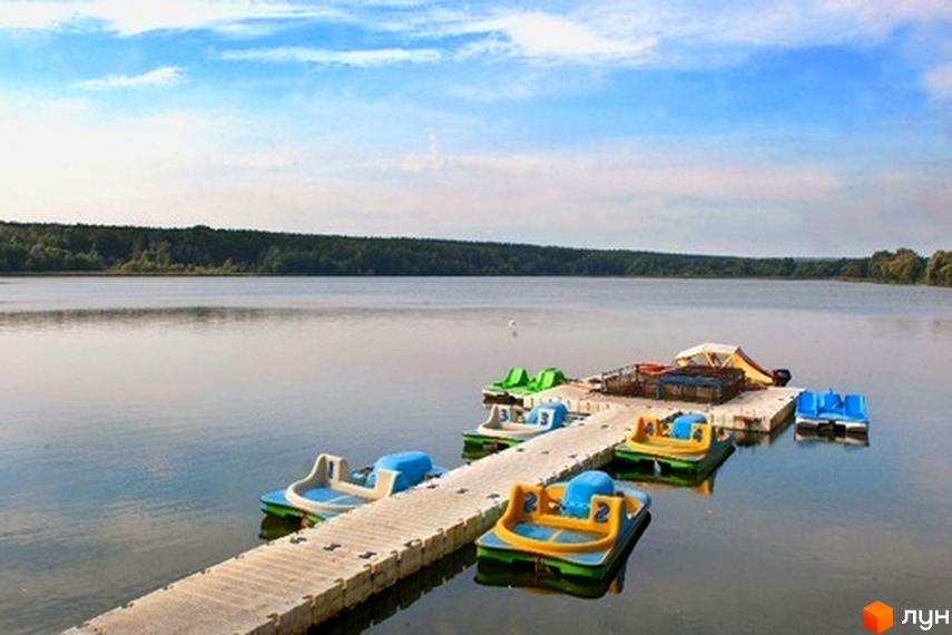 Котеджне містечко Круглик. Набережна з катамаранами на фоні озера та лісу. Відпочинок на природі біля води.