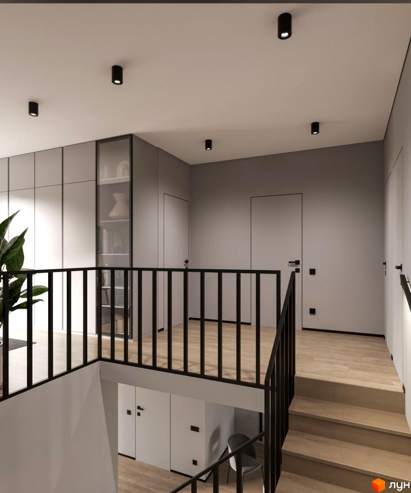 Інтер'єр сходової клітини та другого поверху у житловому комплексі КМ VIVA-CHERNIVTSI. Чорні перила, дерев'яні сходи та підлога, сірі стіни та шафи створюють мінімалістичний дизайн.